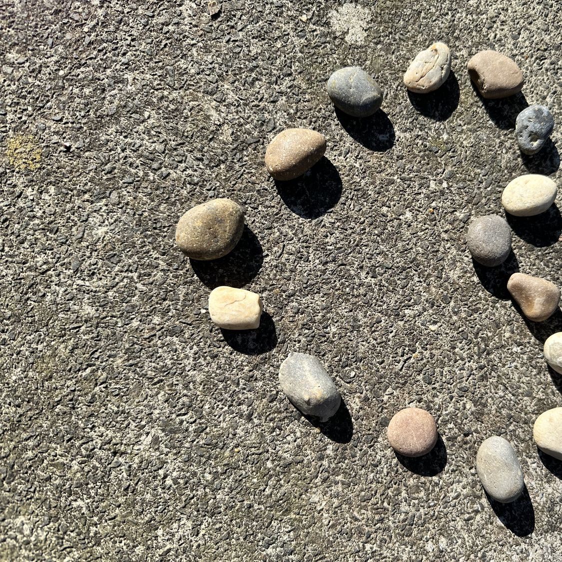 Kleine Steine, die auf dem Sand eines Strandes ein Herz bilden, als Symbol für eine Begegnung ab 50, eine dauerhafte Beziehung und geteilte Liebe.