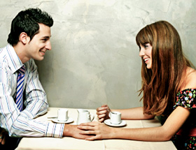 Mann und Frau sitzen im Café und schauen sich verliebt an