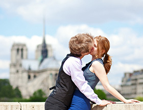 Mann küsst Frau stürmisch auf Brücke