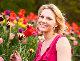 Partnersuche Leoben: eine blonde Frau genießt den Duft frischer Blumen